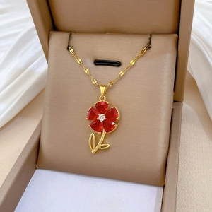 Close-up of red flower pendant necklace with gold leaf on premium gift box display