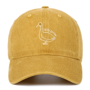 Close-up of silly goose embroidery on mustard yellow washed cotton baseball cap texture