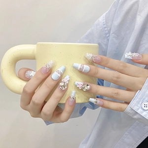 Handmade light blue press-on nails with 3D pink bows, white lace patterns and rhinestones