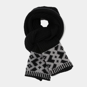 Detail of black chunky knit scarf featuring a stylish leopard print pattern at the ends