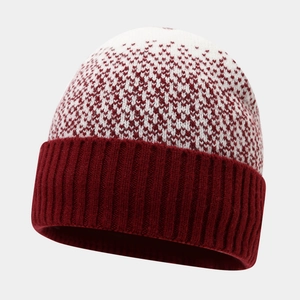 Detail of red and white knit beanie featuring jacquard heart pattern and ribbed cuff
