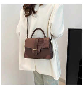 Detailansicht der braunen Kroko-Schultertasche an einem Model im weißen Blazer
