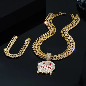 Detail of hip hop jewelry set with gold iced-out cuban chain and skull face pendant