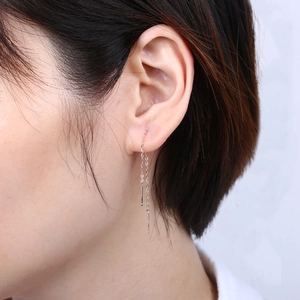 Detail view of long silver S925 threader earrings worn on model for natural drape