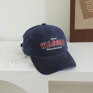 Vue détaillée de la casquette en coton bleu marine avec broderie Wassup sur table