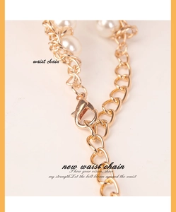 Close-up of golden waist chain featuring white pearls and adjustable lobster clasp closure