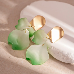 Detail of gradient resin flower petals on a matte gold stud earring with macro focus