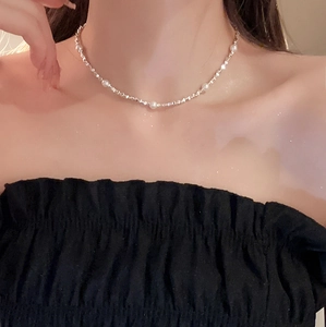 Minimalistisches silbernes Perlen-Choker-Halsband an der Schlüsselbein einer Frau