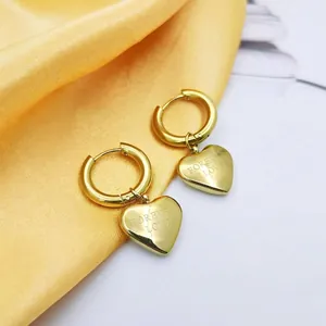 Golden heart drop earrings with Forever Love engraving on satin silk backdrop