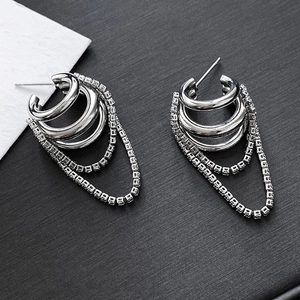 Silver multi-layer chain tassel earrings with sparkling cubic zirconia on a dark background