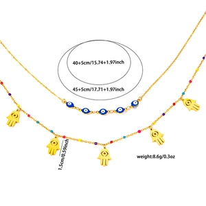 Detailed view of gold double-layered necklace with blue evil eye beads and Hamsa Hand charms