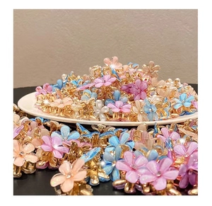 Detailed view of colorful camellia mini hair claws with pearls in a white ceramic dish