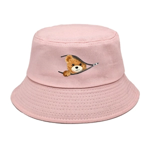 Detail of light pink bucket hat with cute bear print emerging from a zipper detail