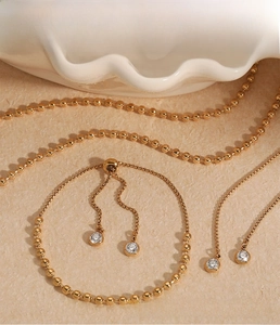 Detailed view of adjustable gold stainless steel necklace and bracelet set with cubic zirconia
