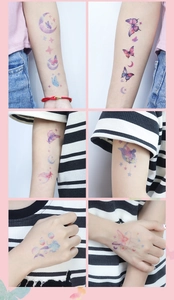 Close-up of colorful butterfly and moon temporary tattoos with dreamlike glitter effect