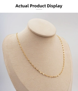 Detailed view of a gold-plated flat link lip chain necklace on a beige mannequin bust