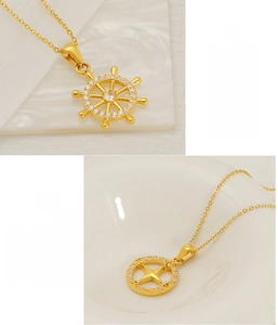 Detail of gold nautical necklaces with sparkling rudder and compass star pendants