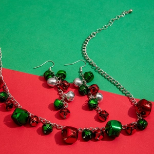 Detailed shot of Christmas jewelry set with red, green, and silver bell charms