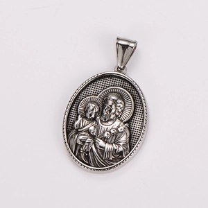 Macro shot of silver stainless steel pendant with religious St. Joseph and Child relief