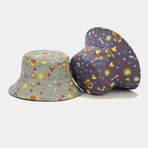 Detail of floral and mushroom print patterns on cotton bucket hats in green and blue