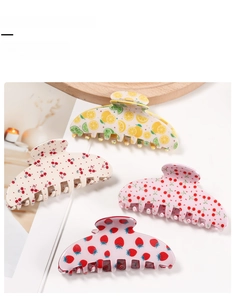 Set of four fruit patterned hair claw clips featuring lemon, cherry and strawberry designs