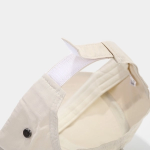Detail of adjustable hook-and-loop strap and beige twill fabric on outdoor ponytail cap