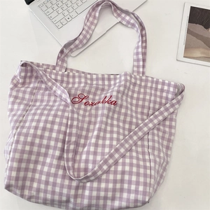 Detailed view of purple plaid canvas tote bag with Sozokka embroidery and laptop prop