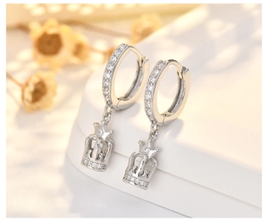 Macro shot of silver crown earrings with shimmering cubic zirconia and drop design