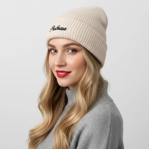 Close-up of beige knitted beanie with black Release embroidery on cuffed edge