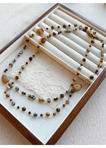 Macro shot of 14K gold plated layered necklace with brown and speckled stone beads