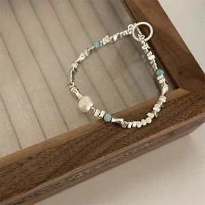Detailed view of silver-toned metal beads, pearls, and turquoise stones with toggle clasp