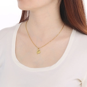 Détail du collier avec pendentif cœur MOM serti de strass porté par un mannequin