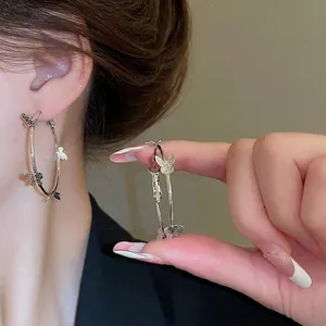 Silver butterfly hoop earrings featuring three dimensional charms for women