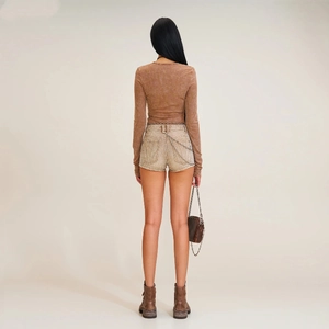 Vue arrière d'un haut en maille marron ajusté avec un short en jean décoré et des bottes