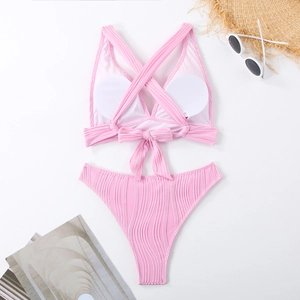Detaillierte Flachbildaufnahme eines rosa Ripp-Bikinis mit Schnürung und Strand-Accessoires