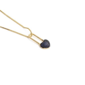 Macro detail of gold box chain necklace featuring a blue pavé heart lock pendant