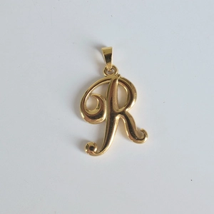 Gros plan du pendentif monogramme lettre R en acier inoxydable doré 18K sur fond blanc