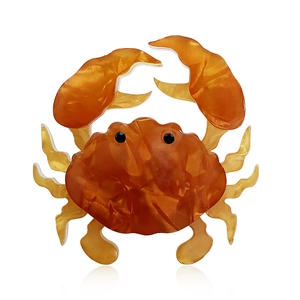 Handcrafted acrylic crab brooch in translucent amber orange for fashion accessories