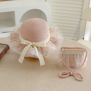 Detailed view of girls pink straw hat and matching bag set with lace and tulle bow accents