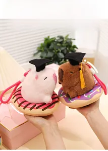 Detailed view of Capybara plush keychain with graduation cap on a donut base