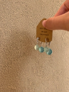 Detail of light green and sky blue resin teardrop earrings with silver metal hooks