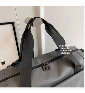 Dettaglio della borsa da viaggio grigia con robusti manici in nylon e zip in metallo