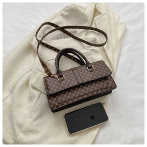 Brown geometric print handbag on beige blazer with elegant accessories and golden hardware