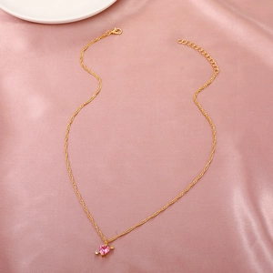 Detailed macro shot of a gold heart pendant necklace on soft pink silk fabric