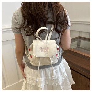 Detailed back view of a white mini backpack featuring pink butterfly and strawberry motifs