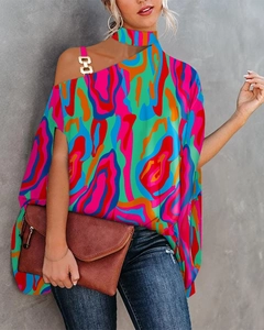 Detail der bunten Bluse mit abstraktem Print, One-Shoulder-Design und goldener Schnalle