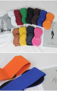 Close-up of wide elastic belt featuring decorative bow buckle in various vibrant colors
