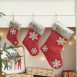 Three red knitted Christmas stockings with snowflake patterns and grey faux fur trim