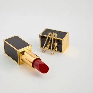 Détail de boucles d'oreilles épingle de sûreté dorées avec pendentif Love et strass