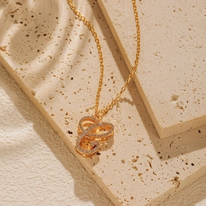 Detail shot of a 18K gold-plated necklace with a crystal-encrusted letter pendant